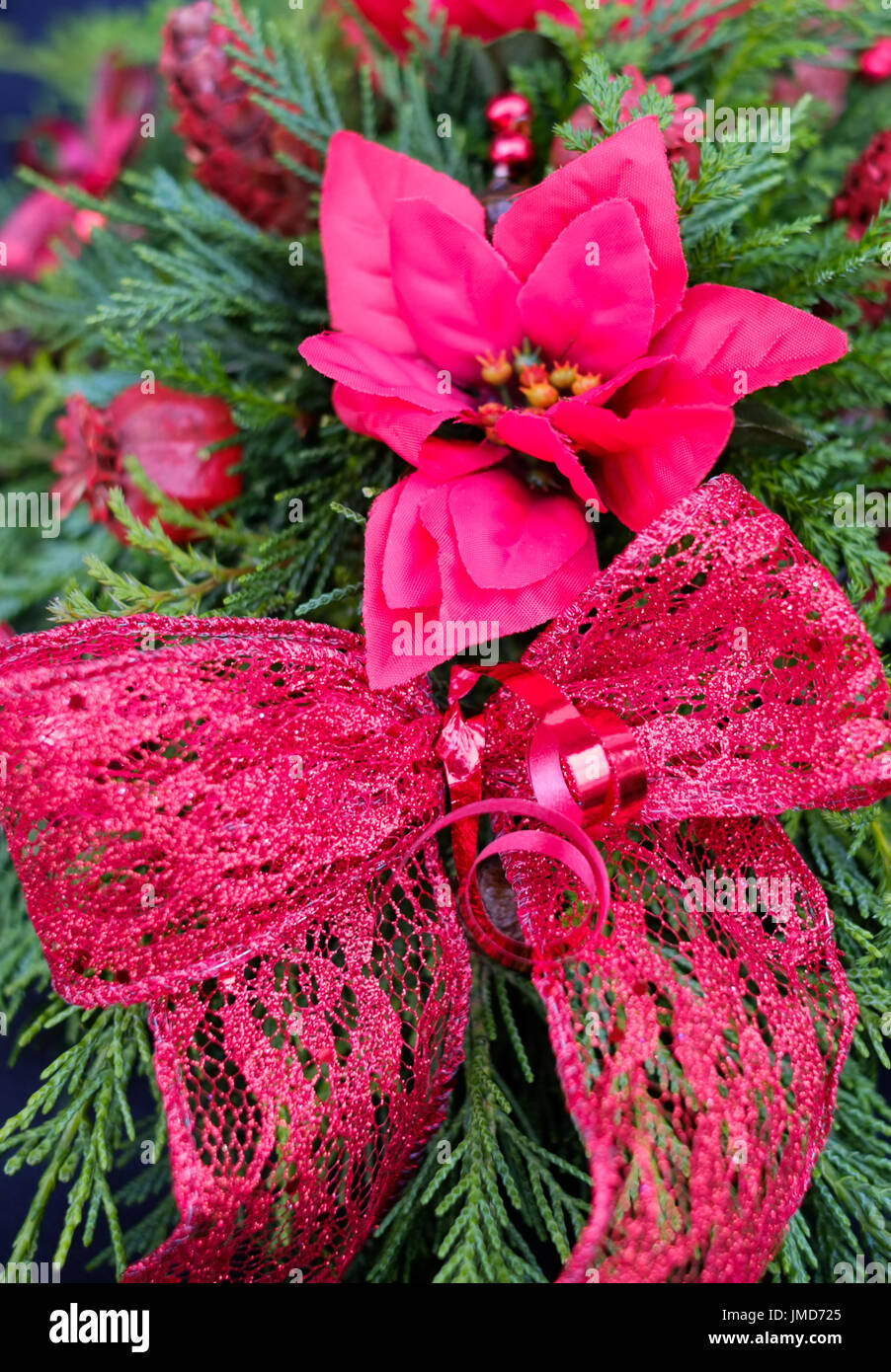 Christmas decoration of bow and artificial flower attached to a wreath. Stock Photo