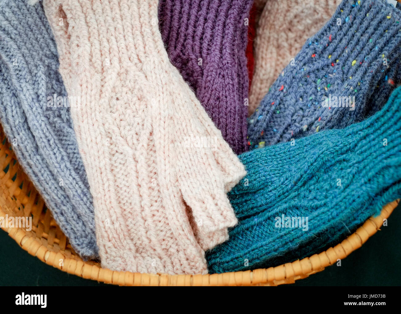 Craftwork displaying hsnd-knitted mittens presented in a basket. Stock Photo