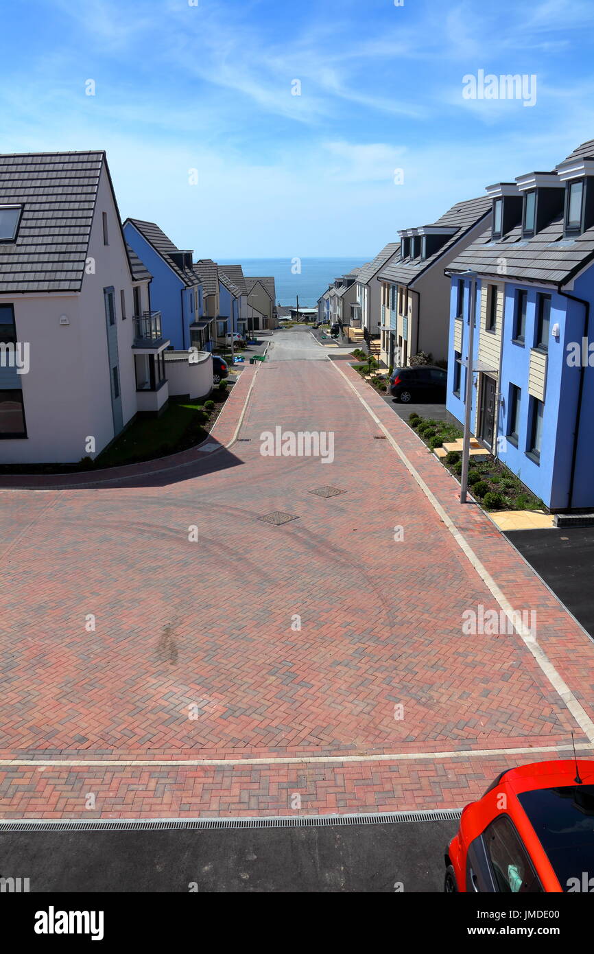 The room with a view, looking out along the street towards the sea with new houses on either side leading downwards to water. Stock Photo