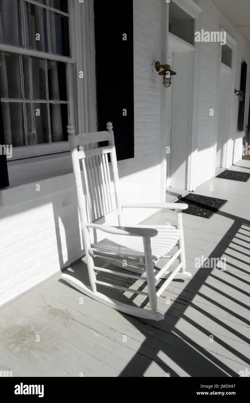 A white rocking chair on an old white porch. Stock Photo