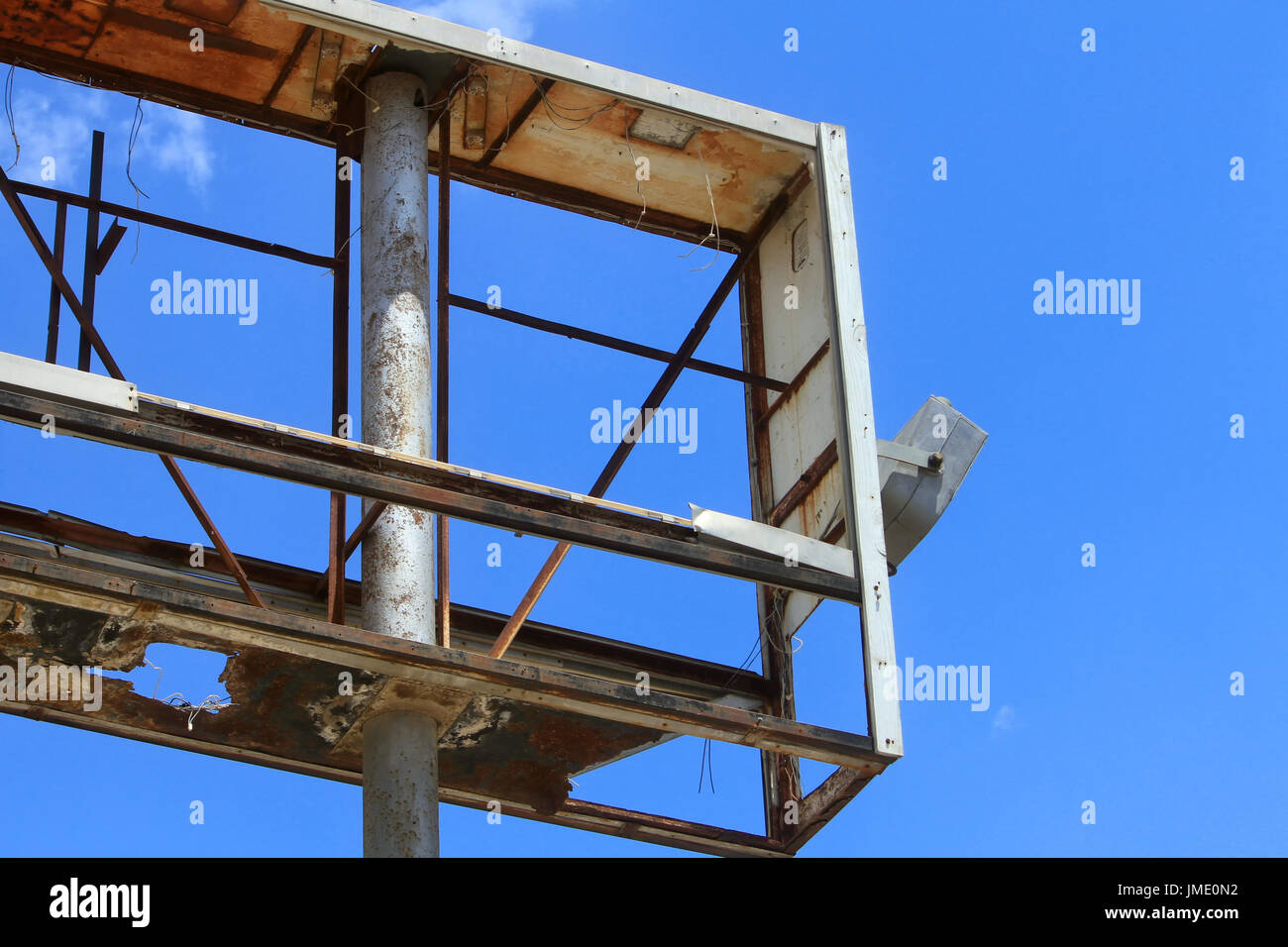 An empty rusted metal sign frame against a blue sky. Stock Photo
