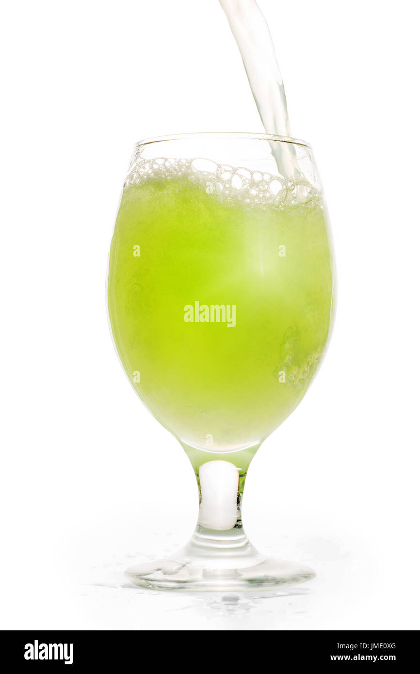 Green refreshing drink pouring into full glass. Isolated on white clipping path included Stock Photo