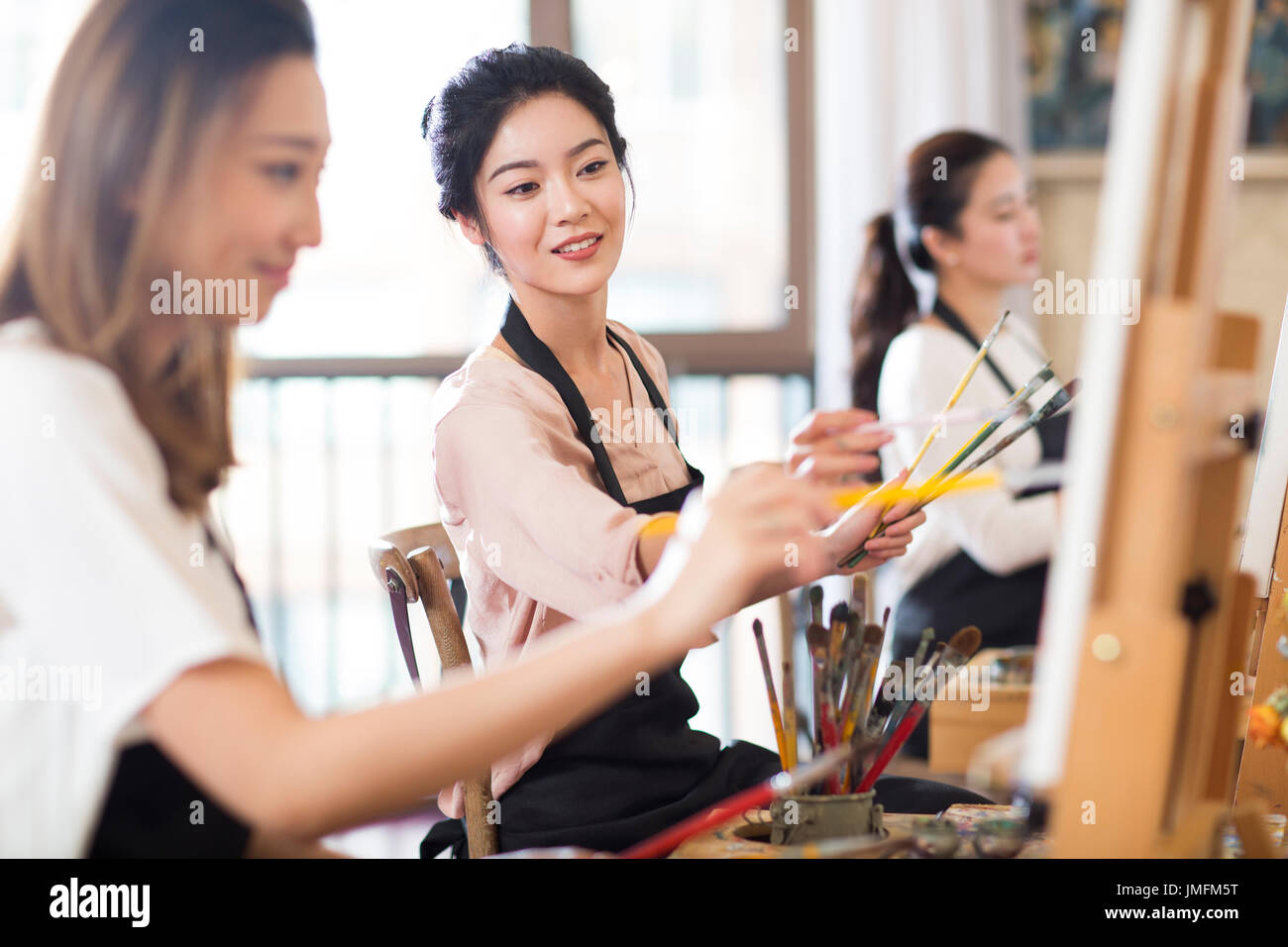 Young women painting in studio Stock Photo - Alamy