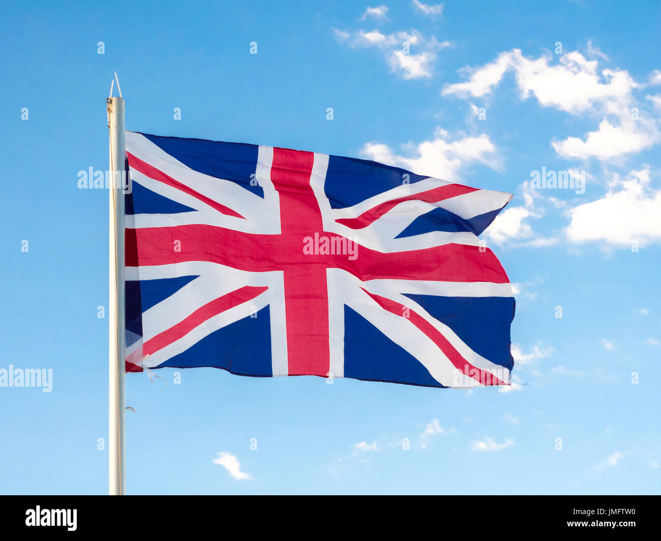 Union Jack, traditional United Kingdom flag, waving in blue sky, copyright space Stock Photo