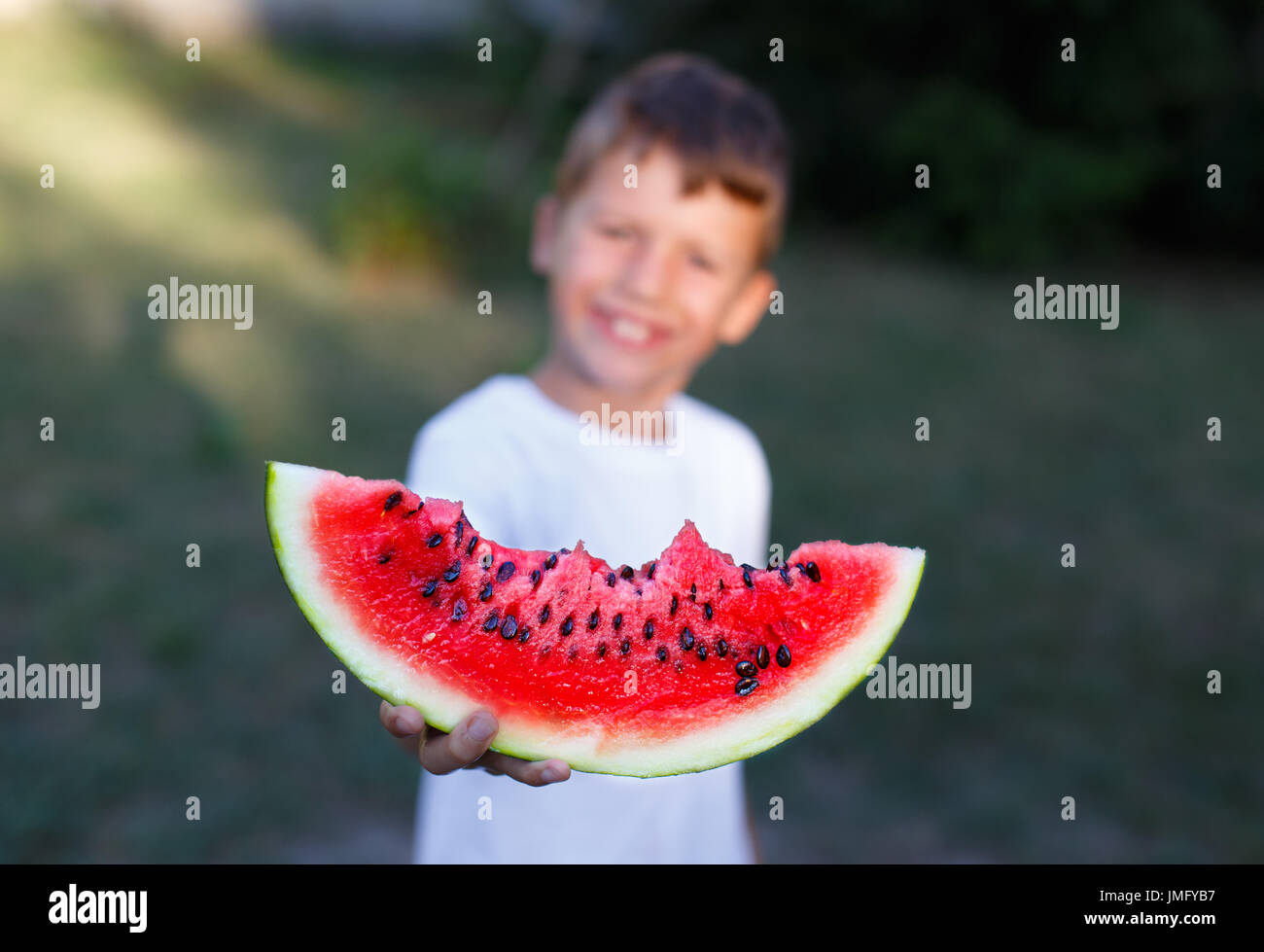 Little boy holding slice of watermelon outdoor, depth of field Stock Photo