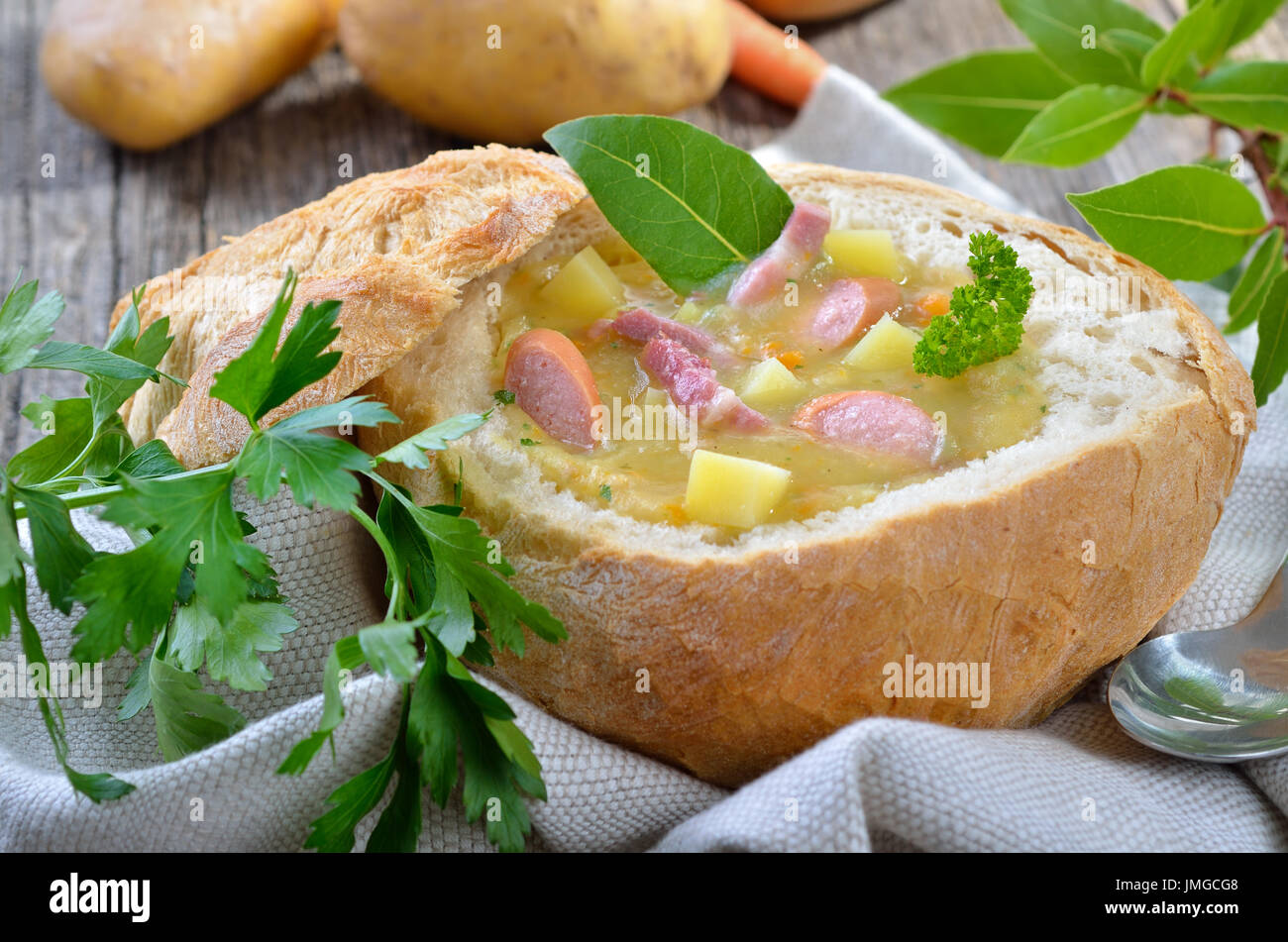 Freshly made potato soup with bacon strips and Vienna sausage wheels served in a loaf of bread
