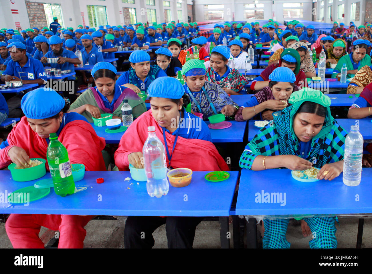 Workers having lunch at a dining room of a readymade garment factory