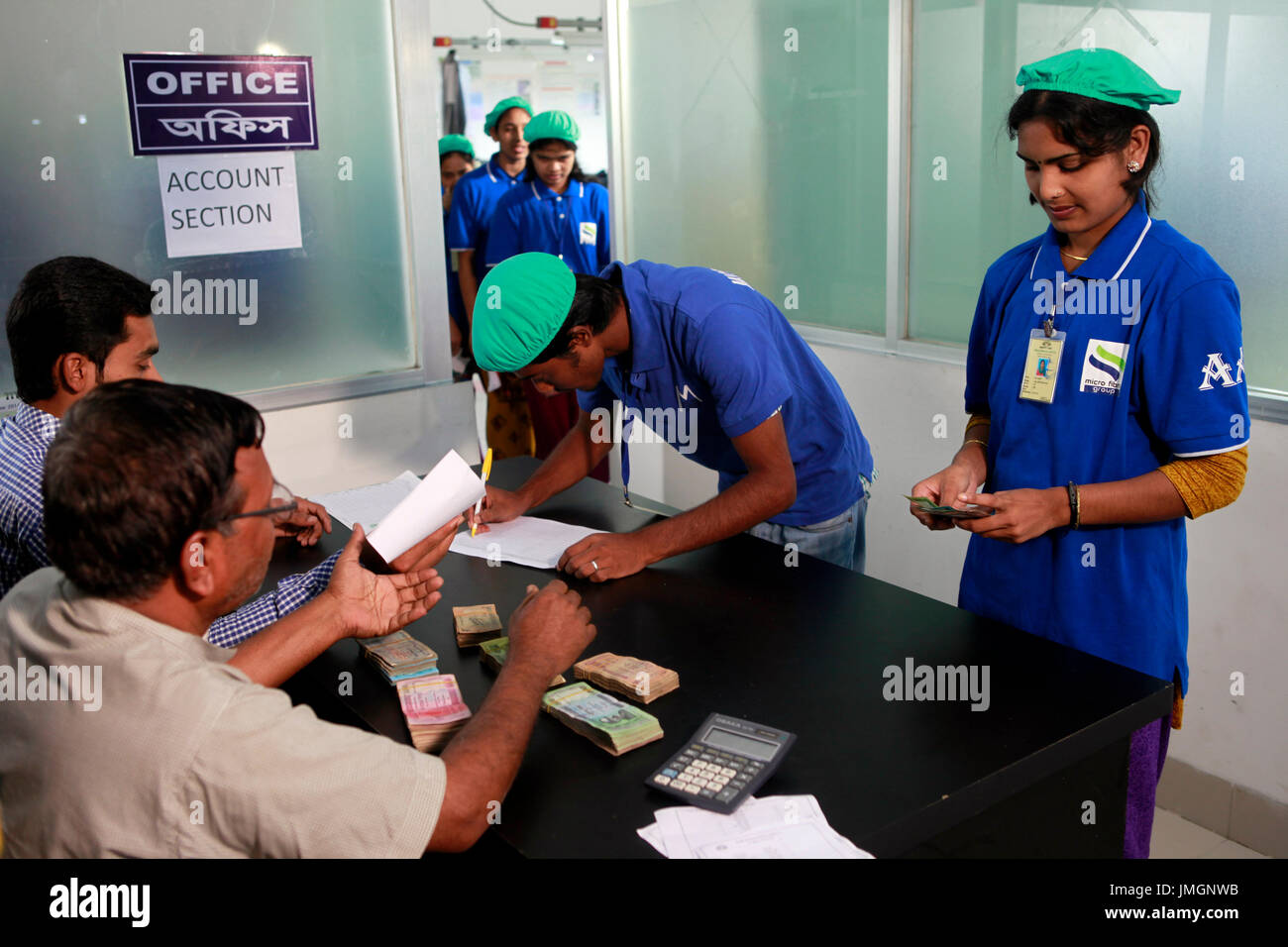 Readymade garment workers receive their monthly salary from an account