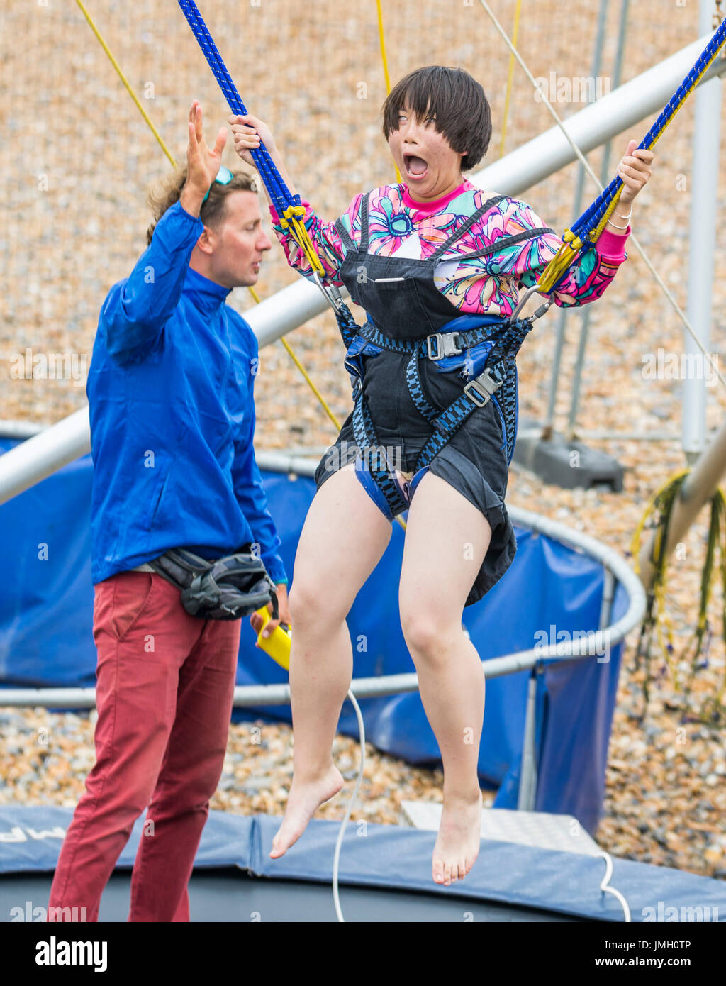 Bungee Jump Trampoline. Young Japanese girl has fun on a Bungee Jump Trampoline. Stock Photo