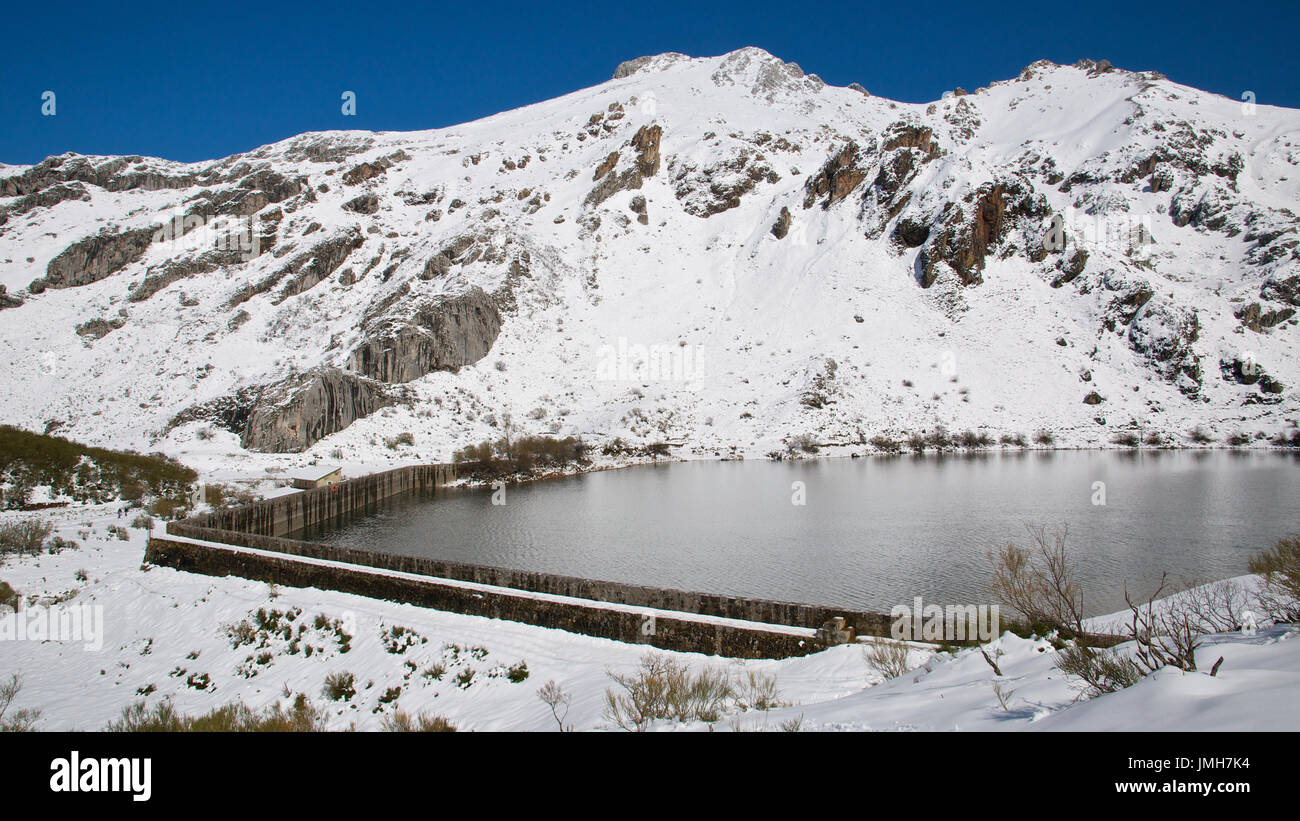 A snowy panoramic view of Lago del Valle lake and surrounding peaks at