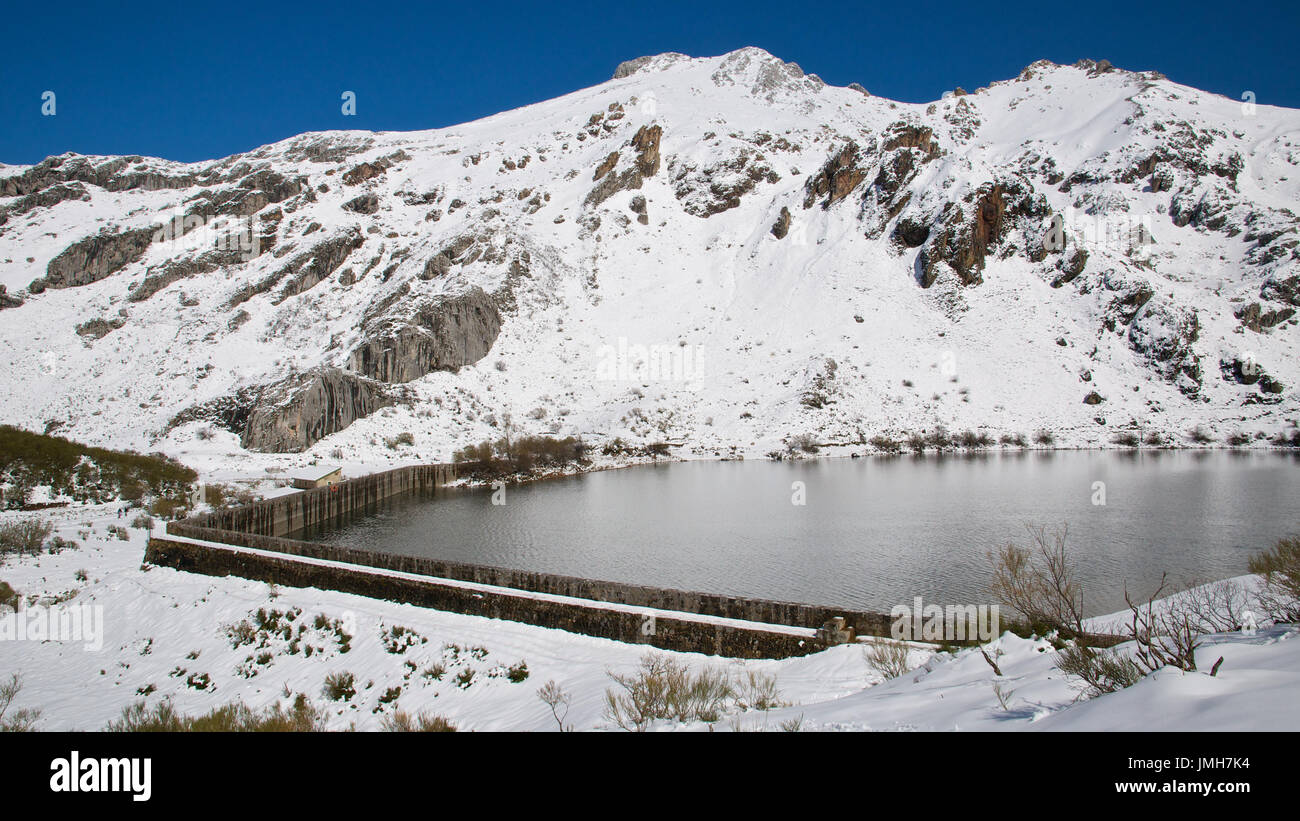 A snowy panoramic view of Lago del Valle lake and surrounding peaks at Somiedo Natural Park (Asturias, Spain) Stock Photo