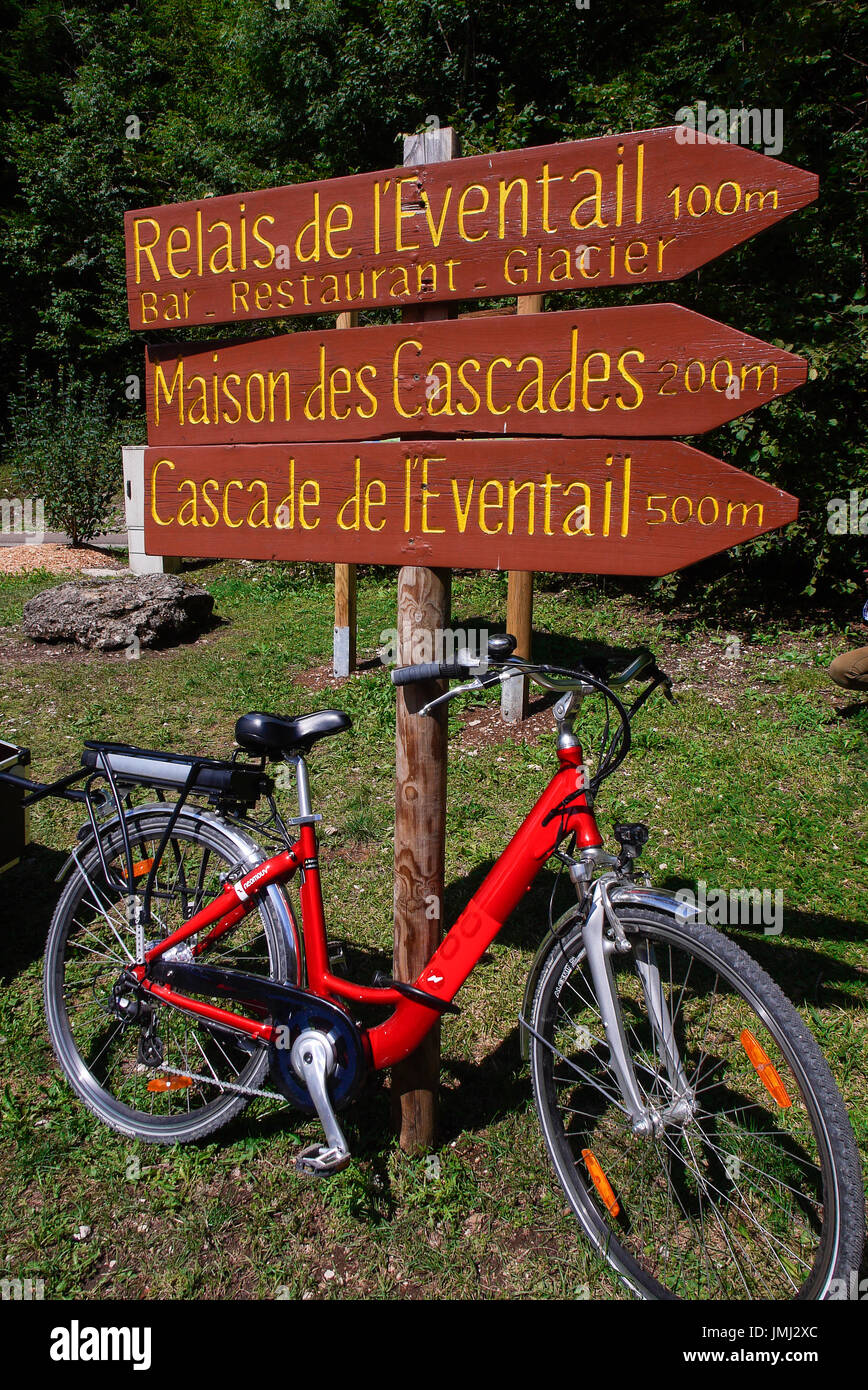 Red bicycle and excursion signs at Herisson Waterfalls, Jura, France ...