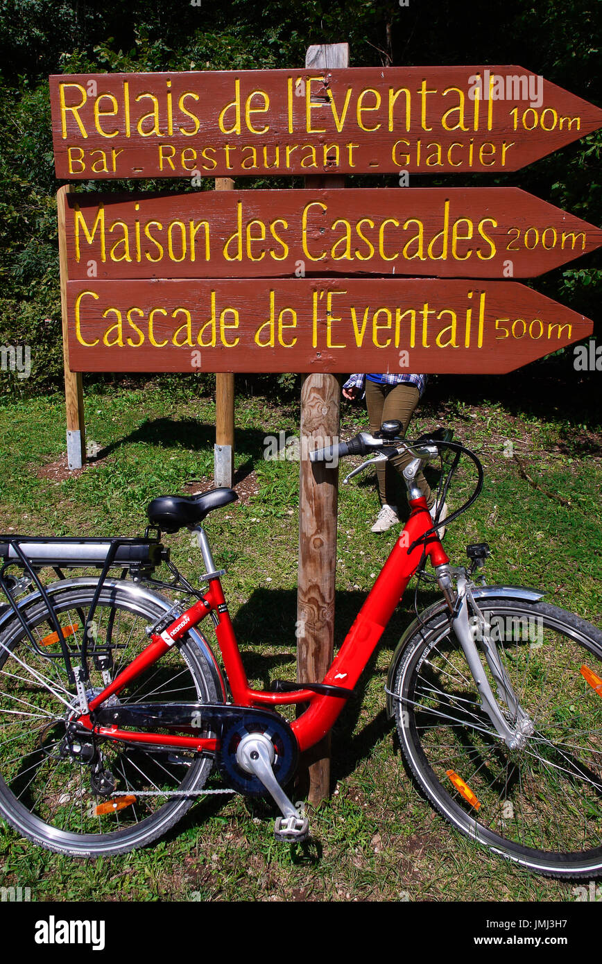 Red bicycle and excursion signs at Herisson Waterfalls, Jura, France ...
