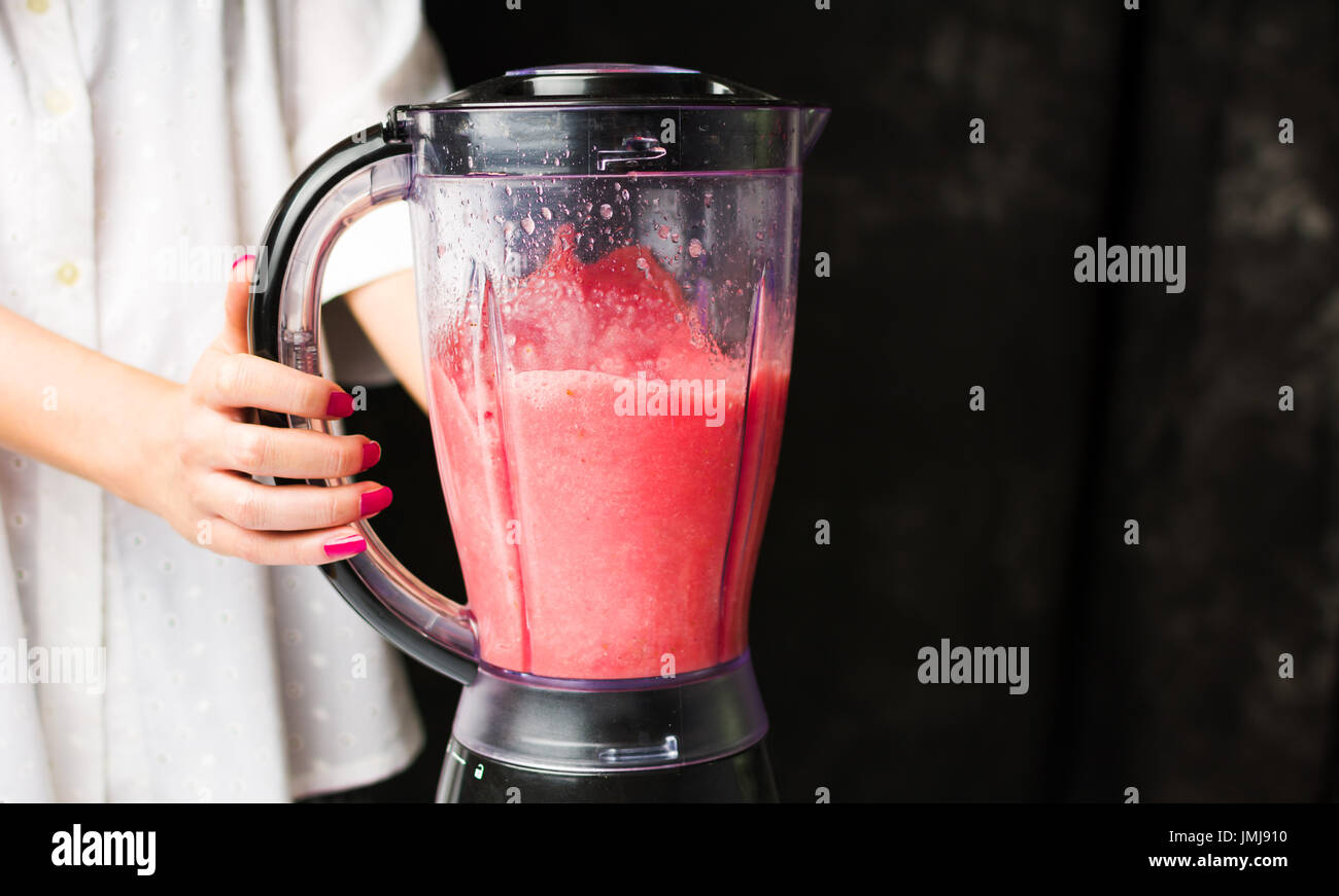 Female making watermelon smoothie with a blender Stock Photo