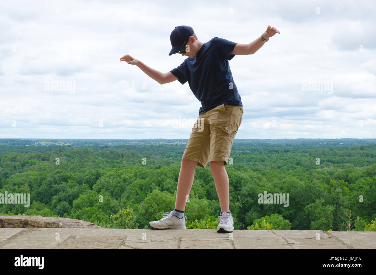 Boy balancing on the edge of a drop - danger concept Stock Photo