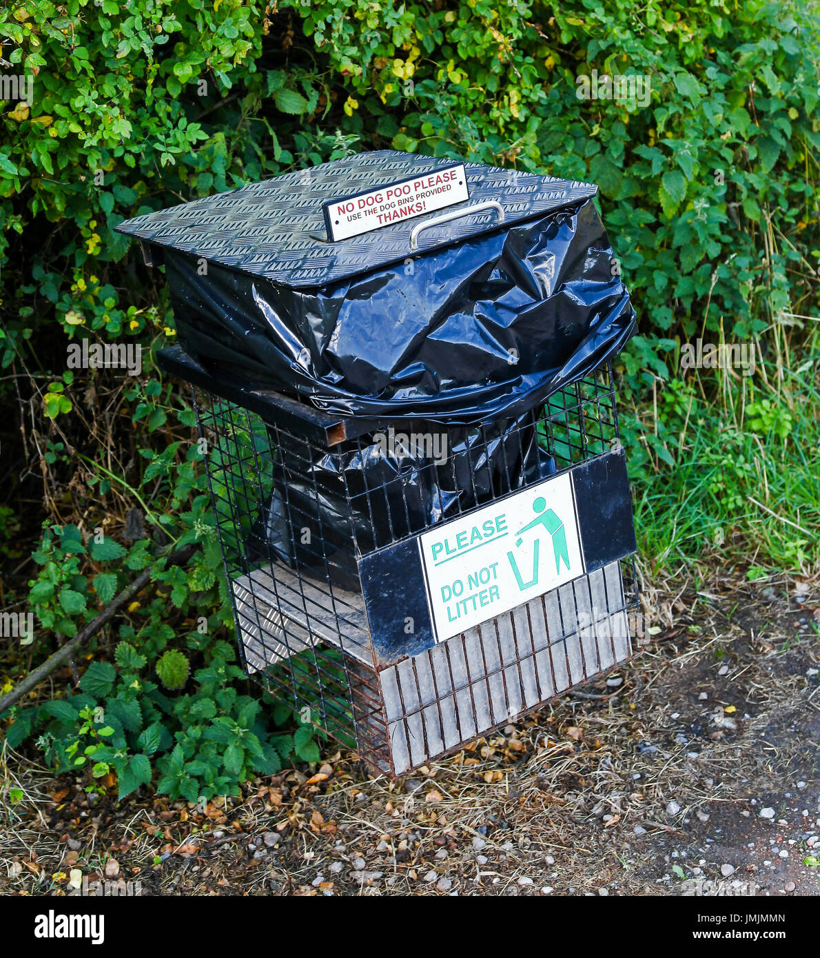 A litter or waste bin with a sign on it saying 'no dog poo please use bins provided' Stock Photo