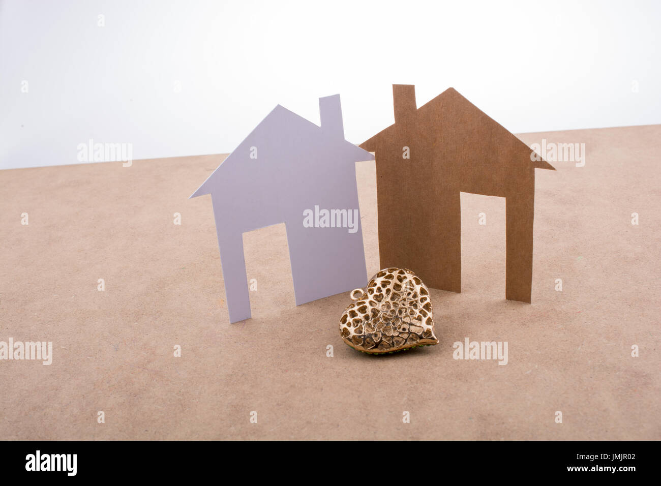 Heart shaped icon and paper houses on a brown background Stock Photo ...