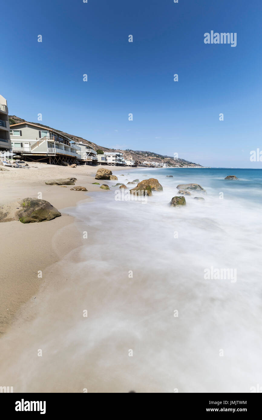 Oceanfront homes with motion blur water at Carbon Beach in Malibu, California. Stock Photo