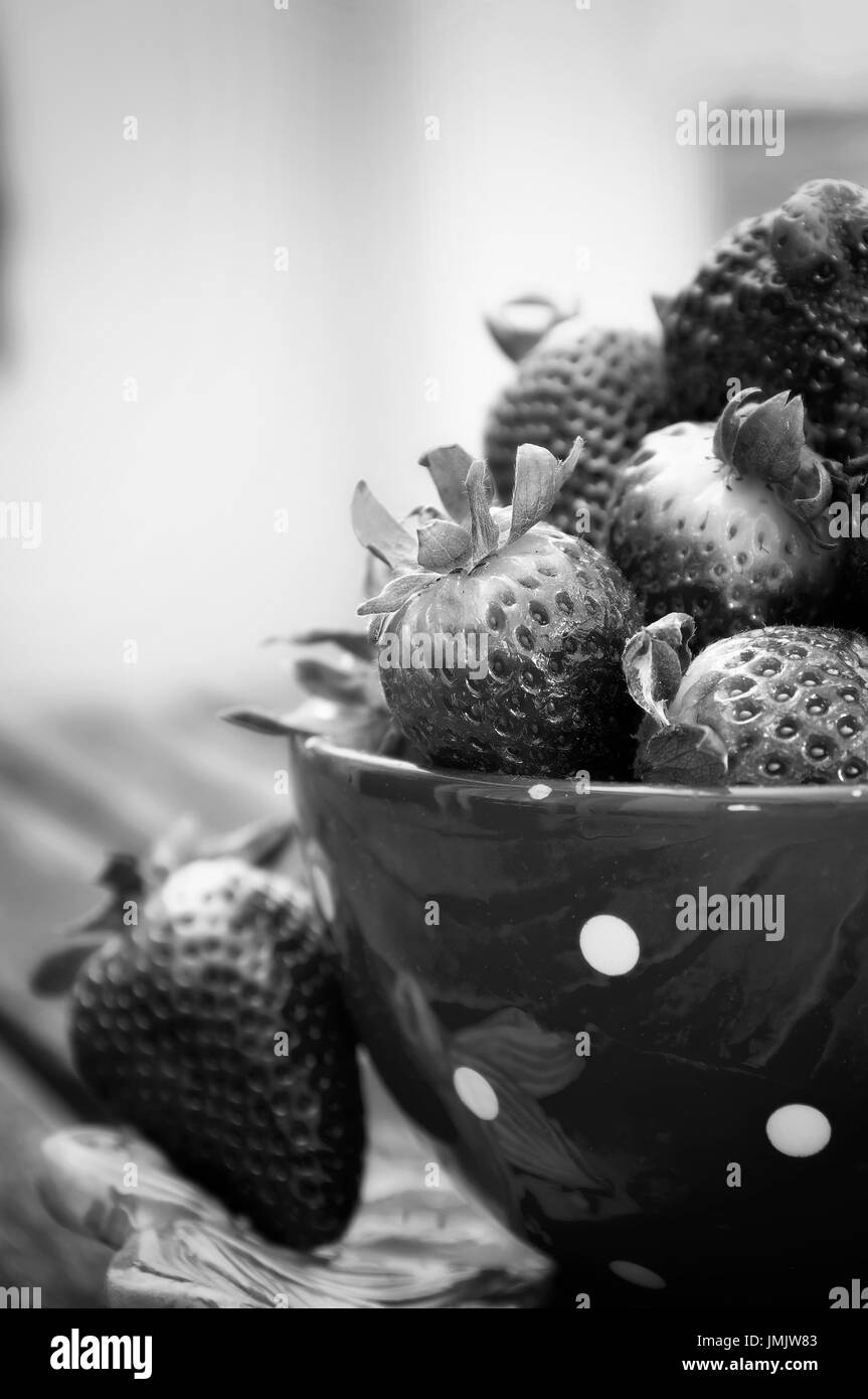 High contract photo of some black strawberries inside a cup Stock Photo