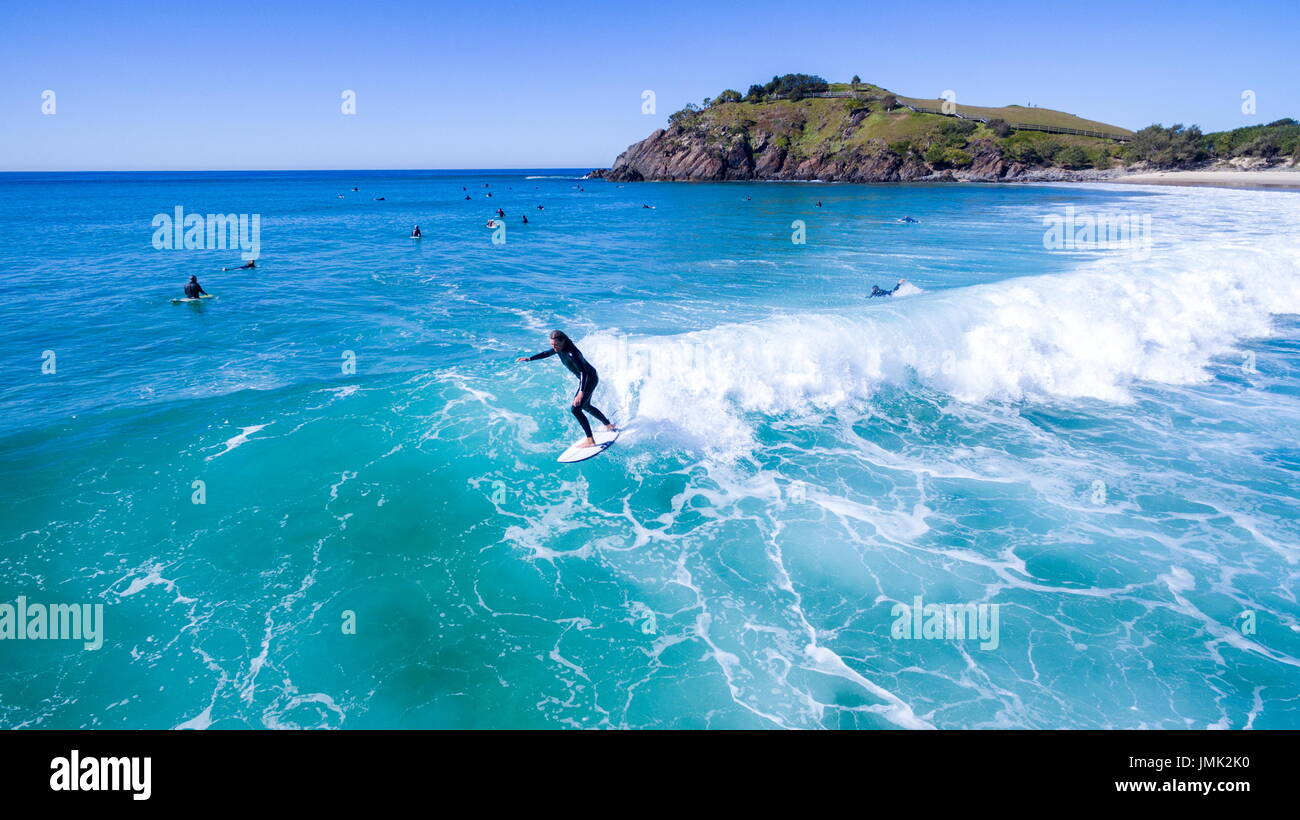 Surfers surfing on crystal clear water. Stock Photo