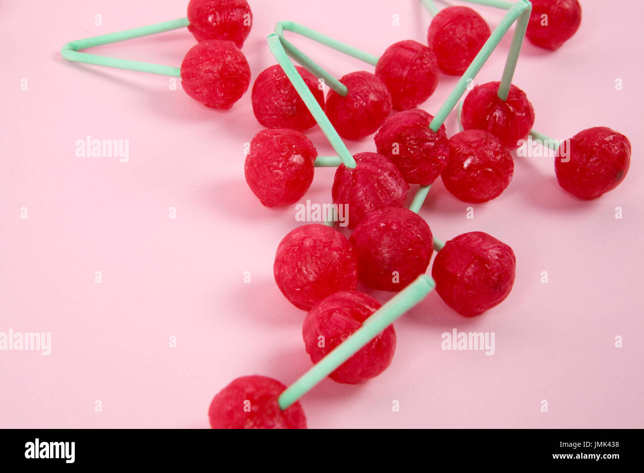 lot of Twin Cherry Lollipops like an old time ago on a pink background with  blur effect. Minimal color still life photography Stock Photo - Alamy