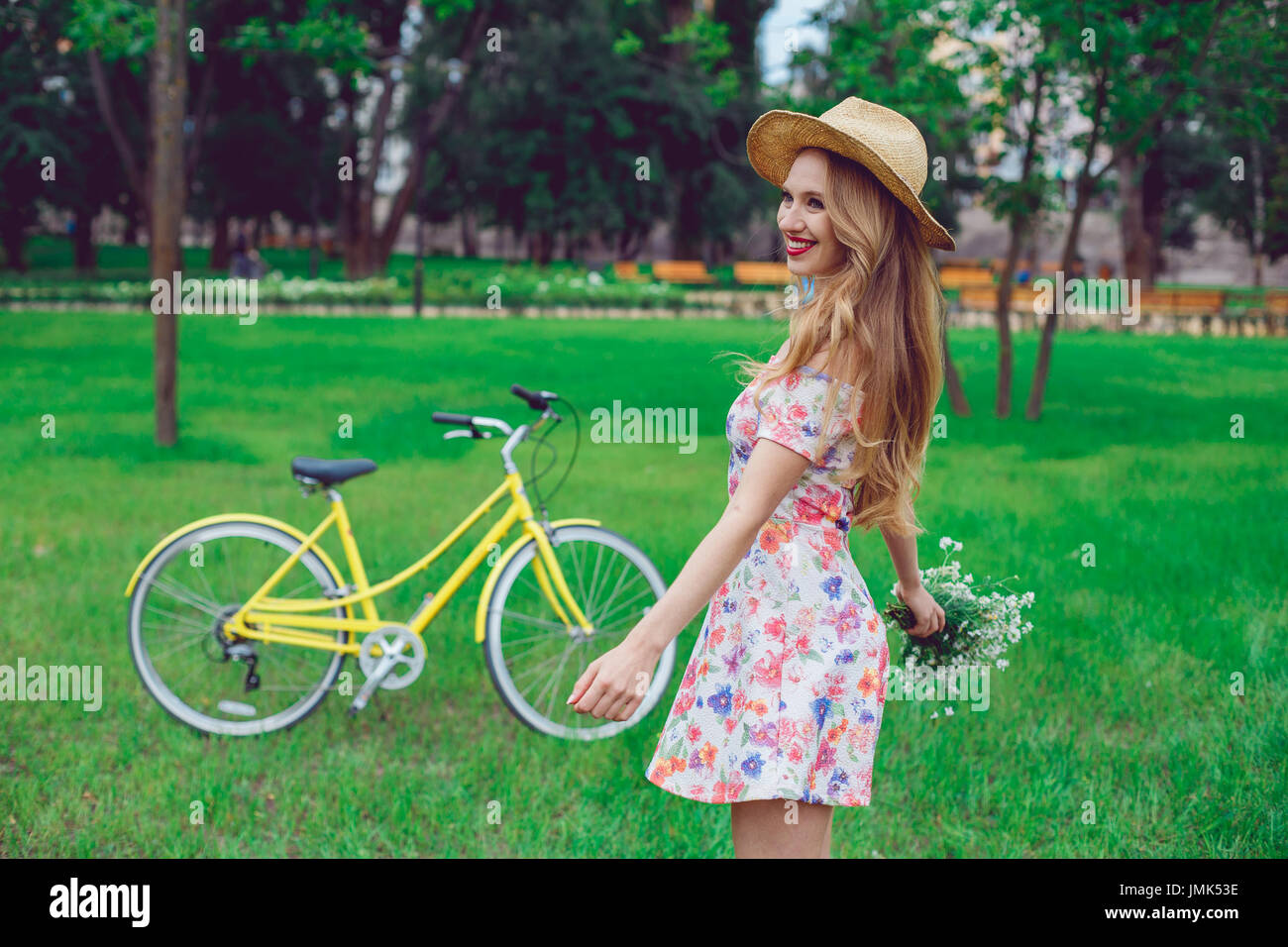 Beautiful happy young woman enjoying summer with wild-flower bunch Stock Photo