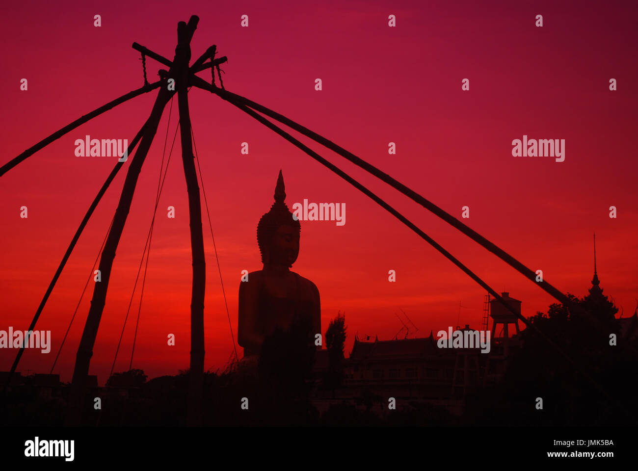Silhouette of Big Buddha statue on sun set with foreground fishing tool. Stock Photo