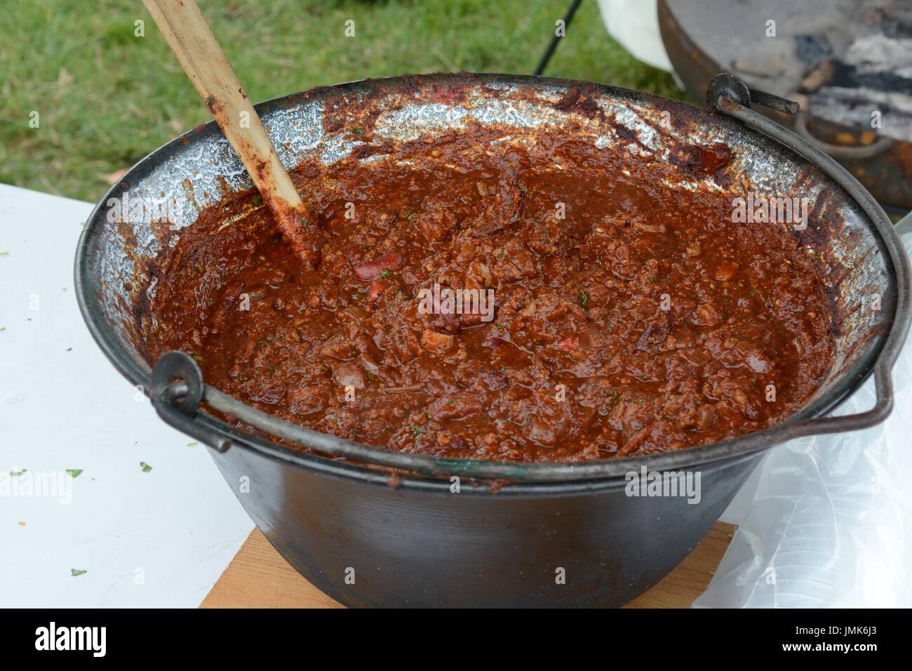 A large bowl of chilli con carne in a cast iron pot cooked over open fire Gower Chilli Festival Glamorgan Wales Stock Photo