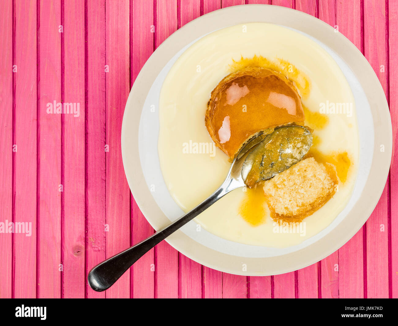 Syrup Or Treacle Sponge Pudding With Custard Against A Pink Wooden ...