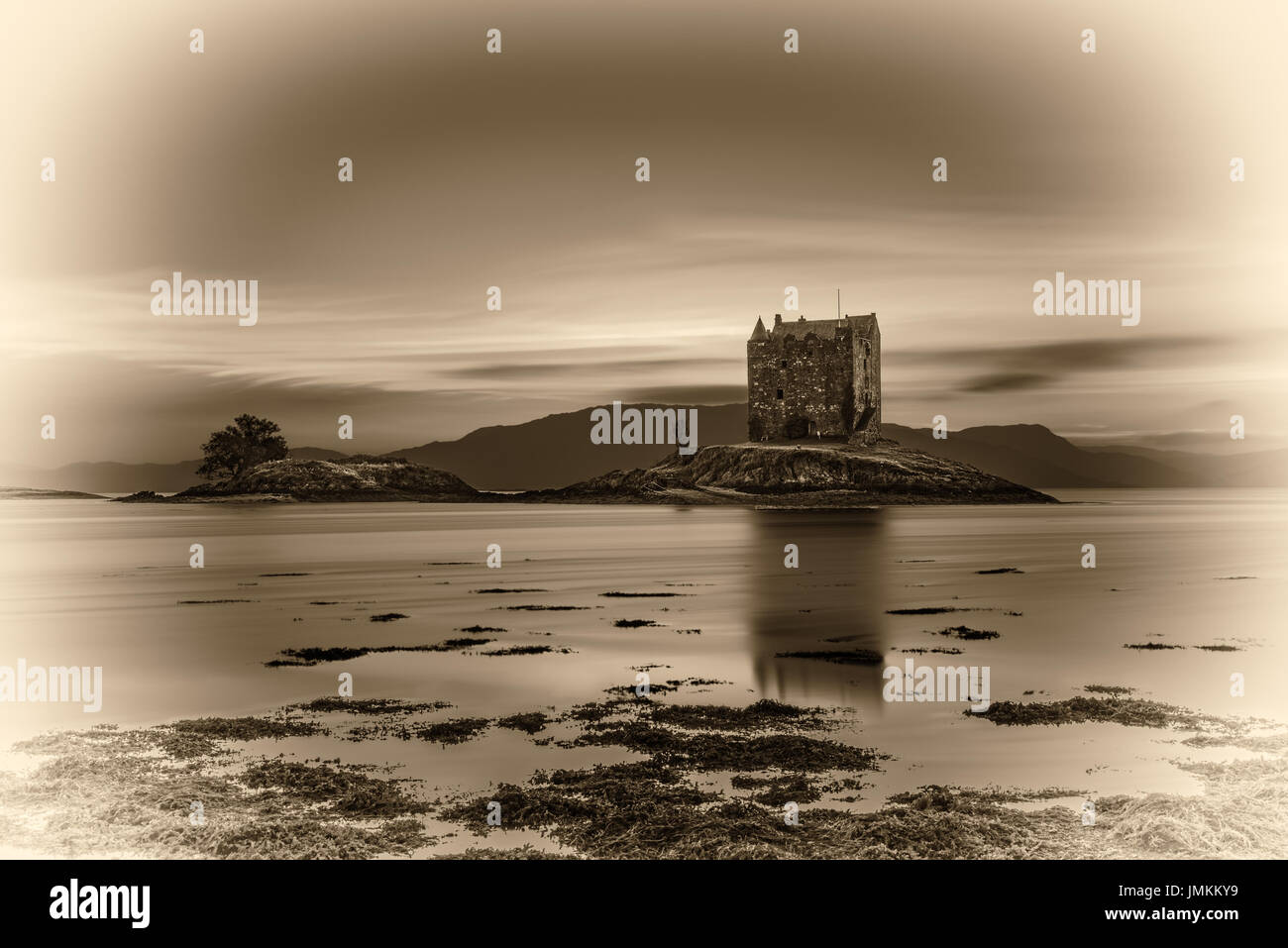 Sunset over Castle Stalker, Highlands, Scotland, United Kingdom. Vintage black and white processed. Stock Photo