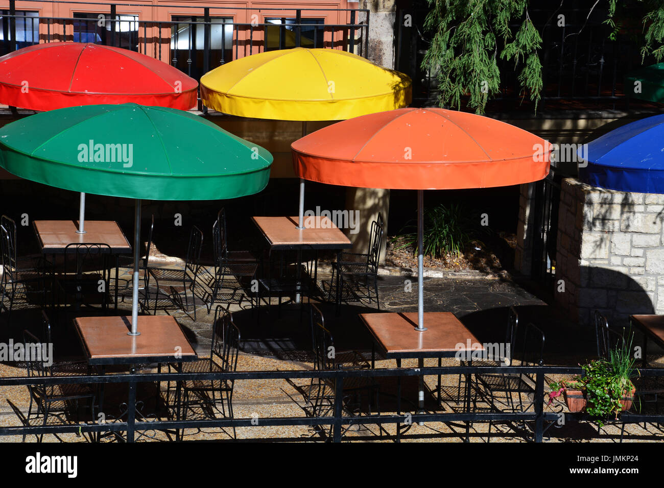 Umbrella shaded restaurant tables along the San Antonio Riverwalk are ...