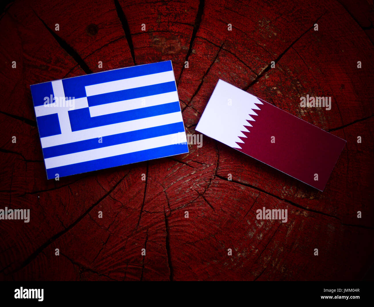 Greek flag with Qatari flag on a tree stump isolated Stock Photo - Alamy