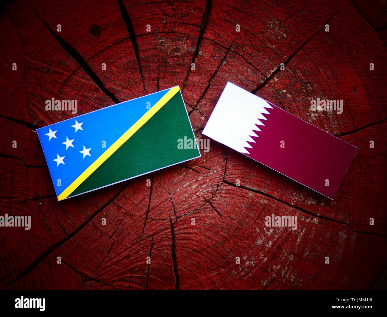 Solomon Islands flag with Qatari flag on a tree stump isolated Stock ...