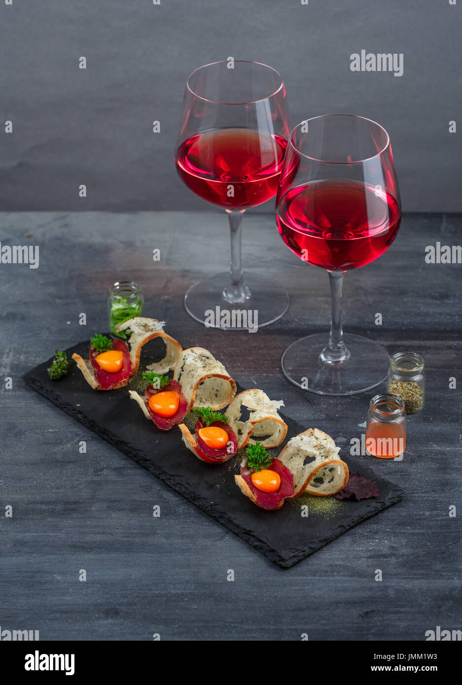 Appetizers cured meat, crusty bread, yolk and cheese on stone board