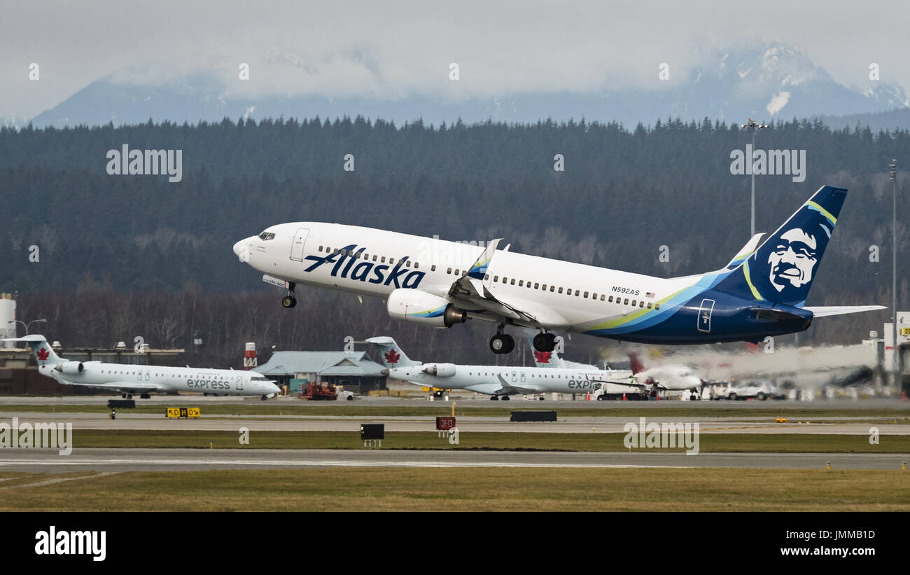 Richmond, British Columbia, Canada. 20th Feb, 2017. An Alaska Airlines Boeing 737 (737-800) narrow-body single-aisle jet airliner takes off from Vancouver International Airport. In the background are regional airliners belonging to Air Canada Express Credit: Bayne Stanley/ZUMA Wire/Alamy Live News Stock Photo