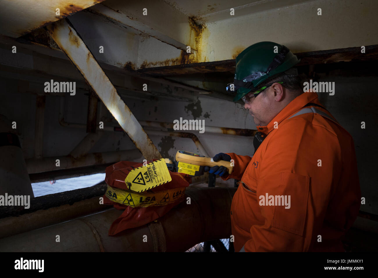 Image of an offshore industrial hygienist testing for LSA / NORM radioactive material. On a north sea oil and gas rig. credit: LEE RAMSDEN / ALAMY Stock Photo