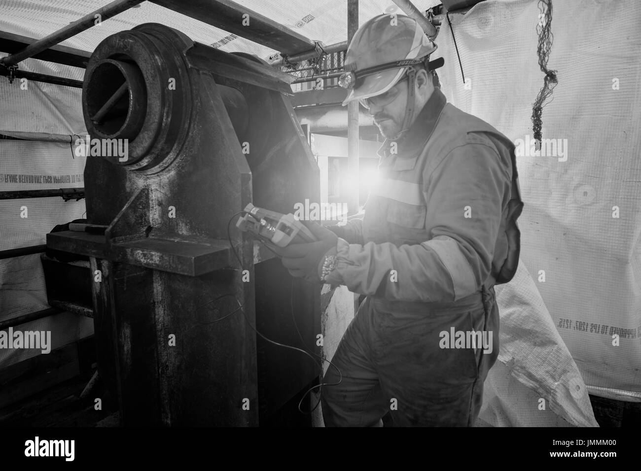 Black and white image, of a NDT inspector, weld thickness checking, on a north sea oil and gas industry rig. credit: LEE RAMSDEN / ALAMY Stock Photo