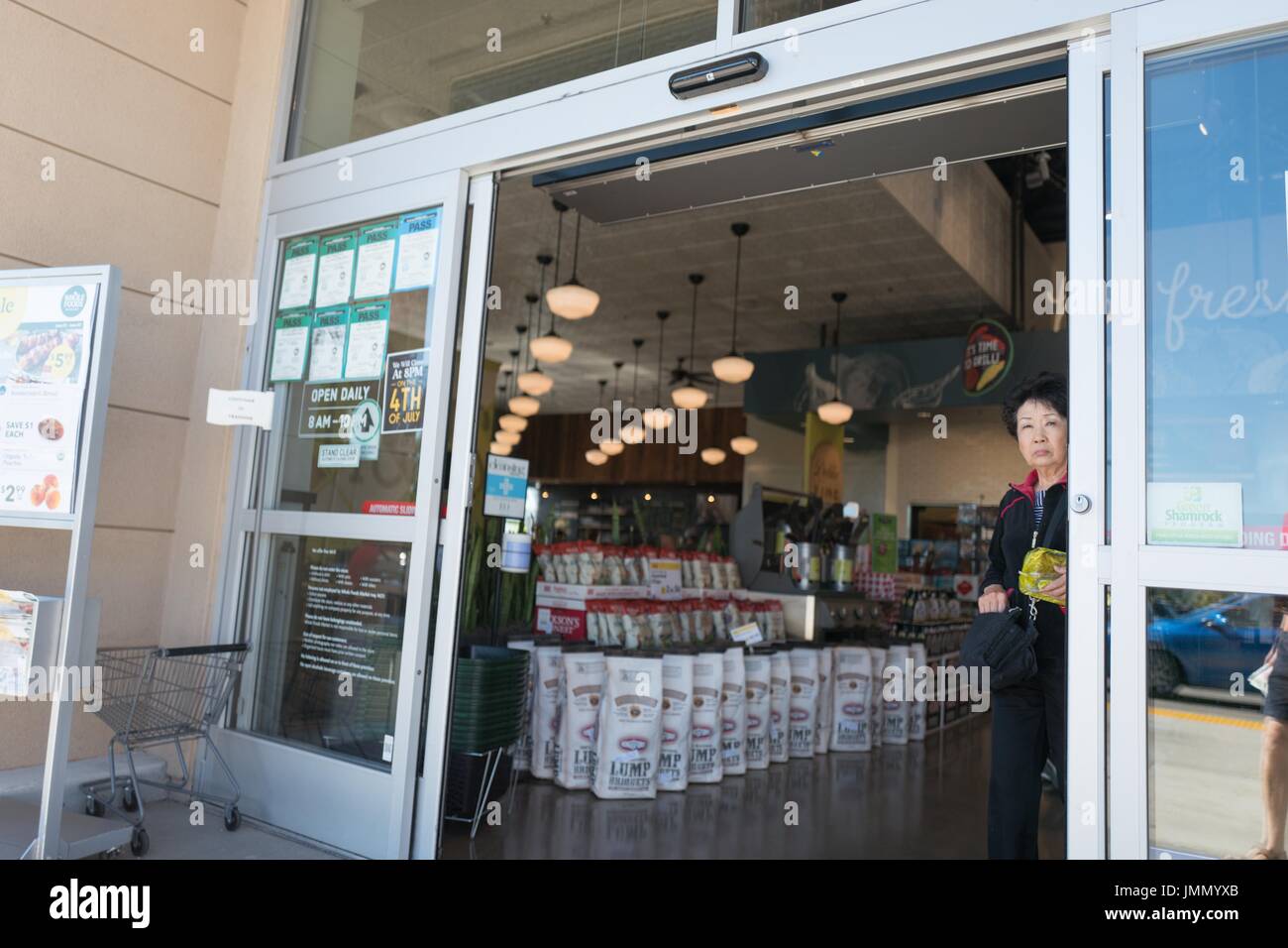 Mature woman exiting Whole Foods Market grocery store in Dublin