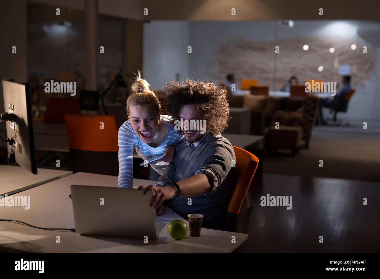 Two young designers are working on a new project in the night office ...