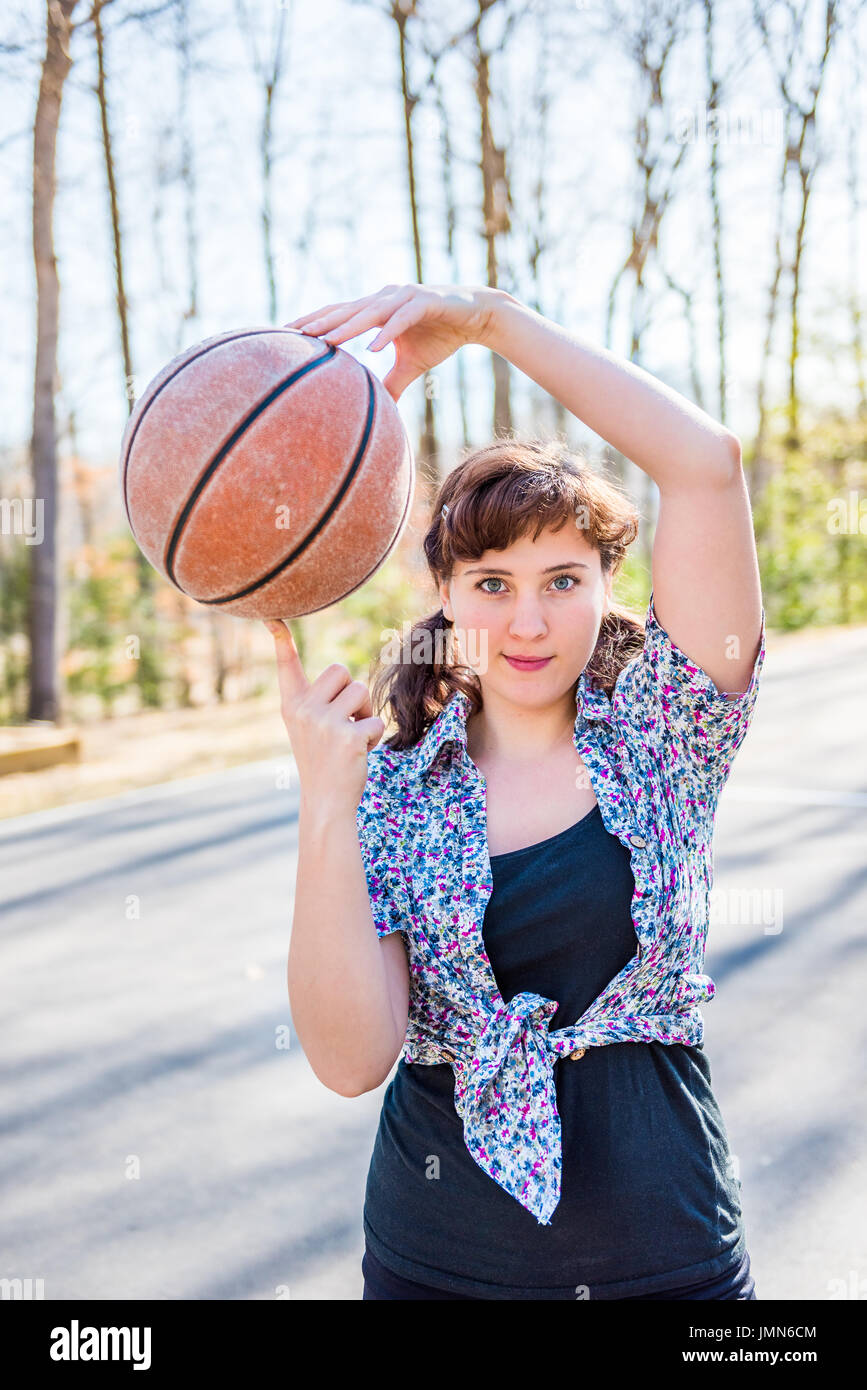 Young fit woman holding basketball in playground Stock Photo - Alamy