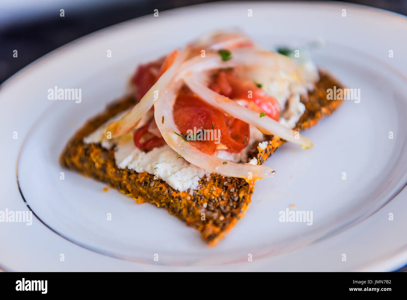 Macro closeup of healthy onion appetizer on chia flatbread toast and cheese Stock Photo