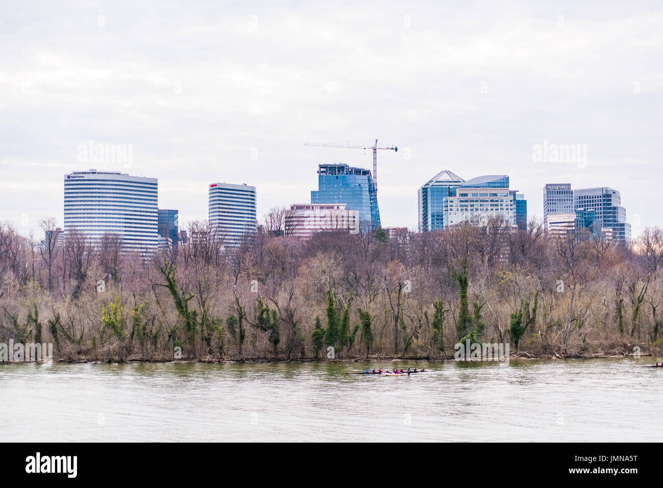 Washington DC, USA - March 20, 2017: People rowing on Potomac river on boat with skyline of Arlington skyscrapers in Virginia Stock Photo