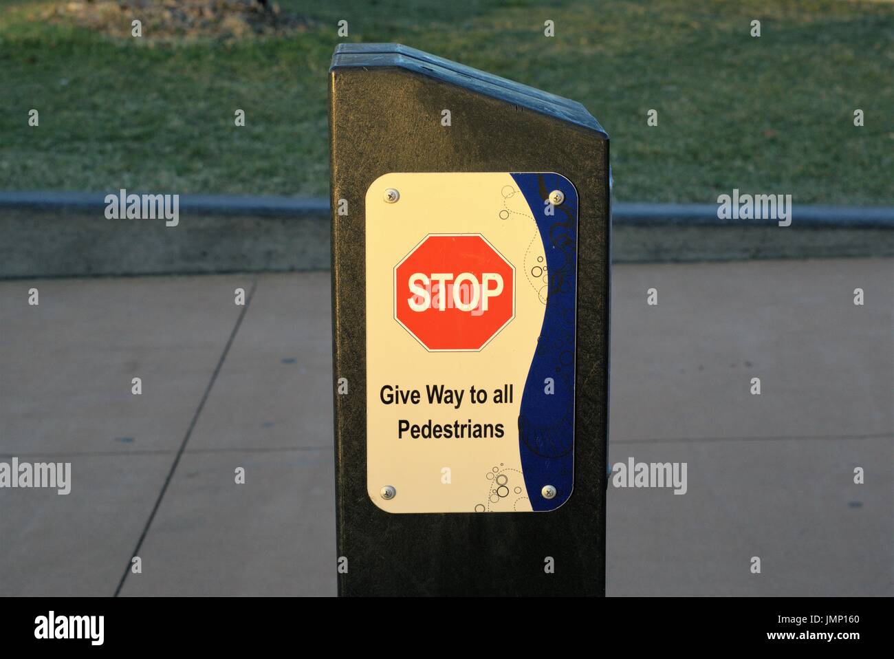 Red Stop Sign on pillar. Sign post at a public place says 'Stop Give Way to all Pedestrians' Stock Photo