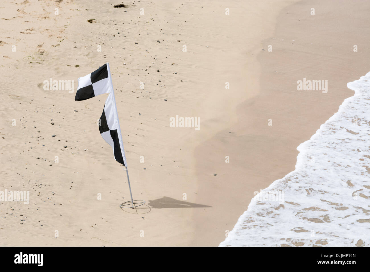Black and white beach flags between 2 of these flags on a beach
