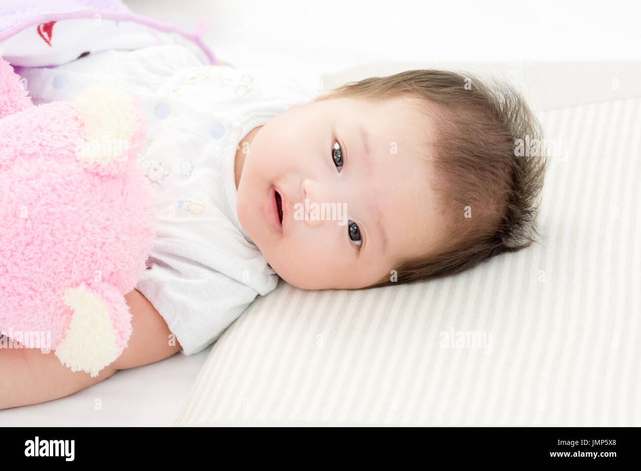 Portrait of adorable baby girl lying on the bed Stock Photo