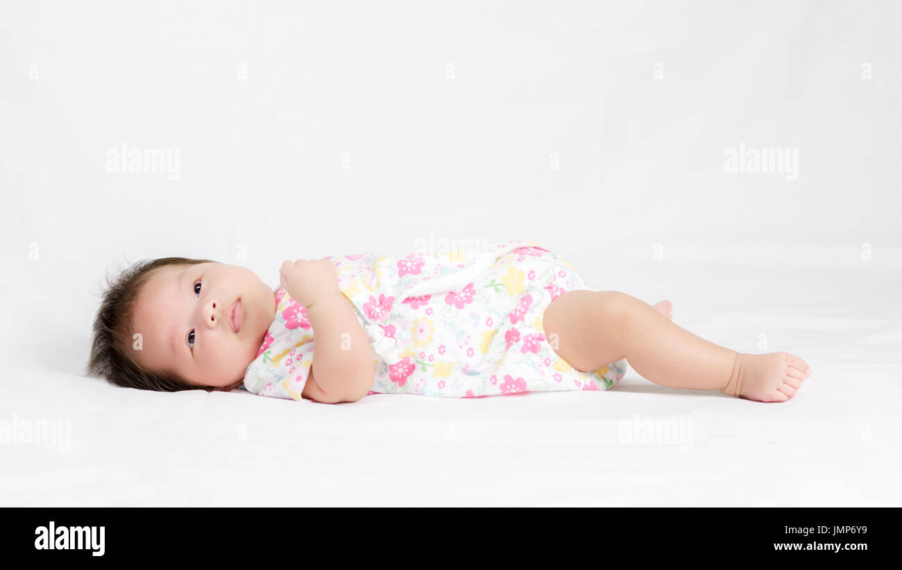 Portrait of adorable baby girl lying on white Stock Photo - Alamy