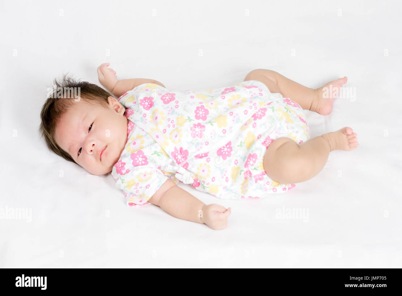 Portrait of adorable baby girl lying on white Stock Photo - Alamy