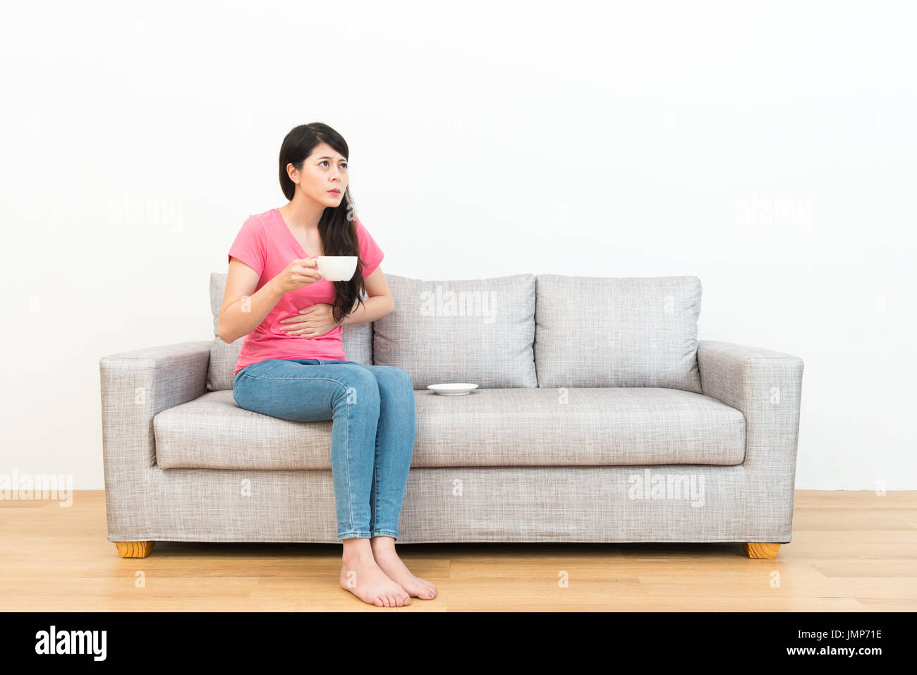 beautiful pretty woman drinking hot beverage feeling abdomen painful