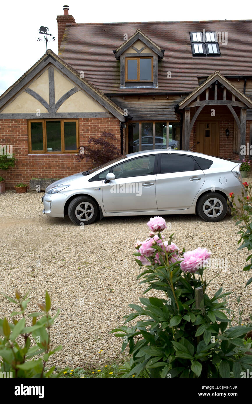 Toyota Prius plugin hybrid PHEV parked outside award winning ecohouse Cotswolds UK Stock Photo