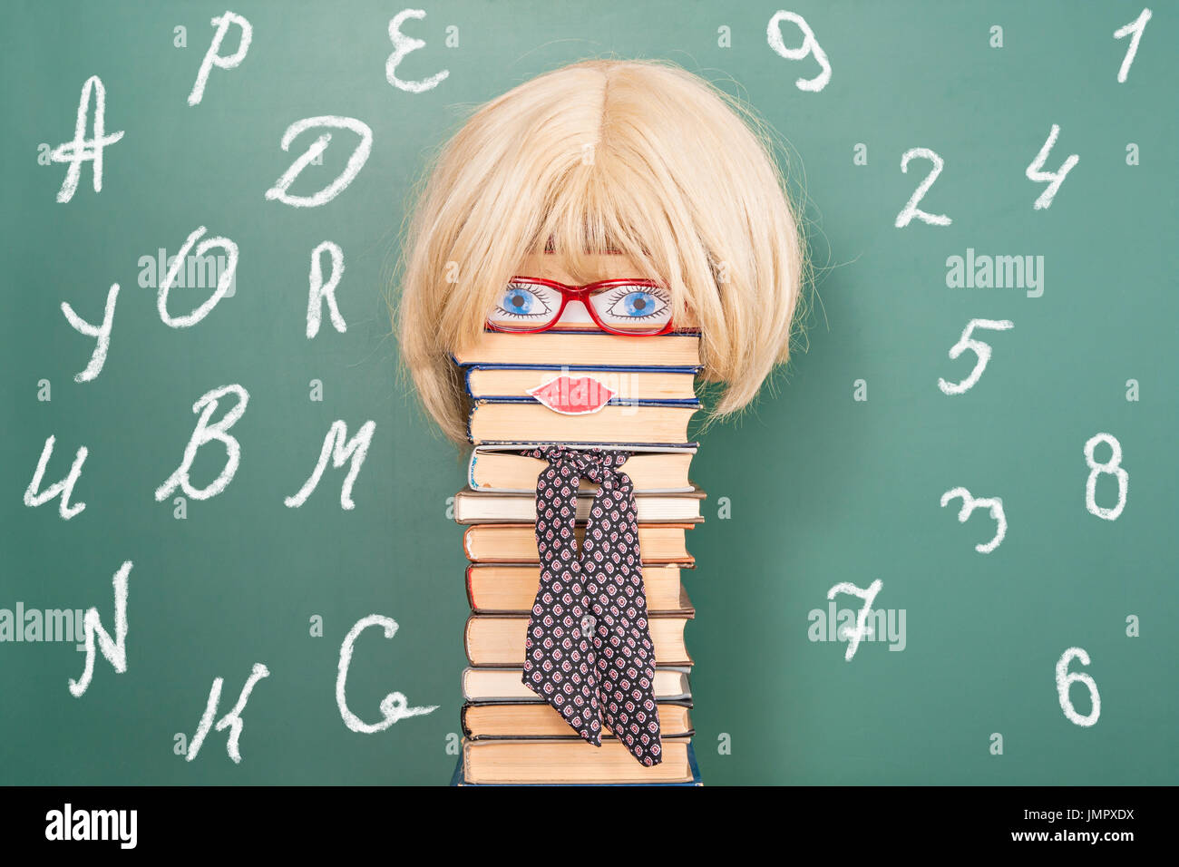 Funny education idea, woman teacher in front of blackboard with copy space Stock Photo